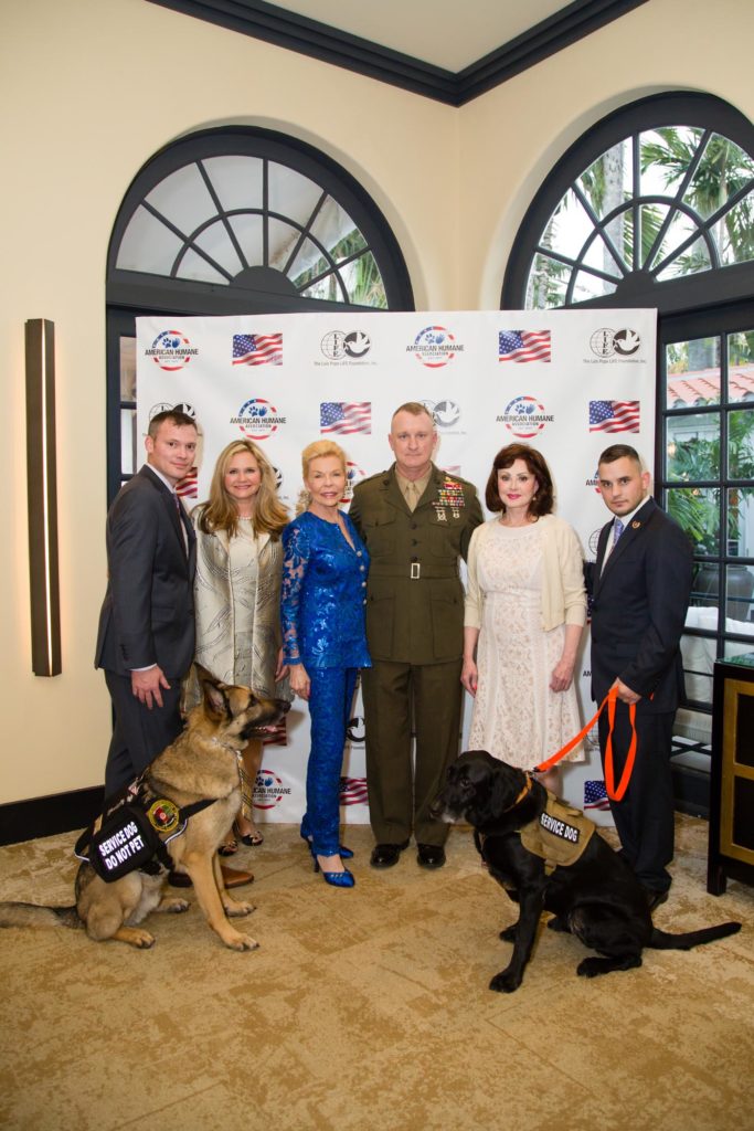 The other photo features (from left): Capt. Jason Haag, USMC (Ret.), American Humane Association’s National Director of Military Affairs, and his service dog Axel; American Humane Association President and CEO Dr. Robin Ganzert; Mrs. Pope; Col. Campbell; Country music legend and American Humane Association board member Naomi Judd; and Lance Corporal Jeff DeYoung, USMC (Ret.) and his retired Military Working Dog Cena. Image source: Kim Zuccaro/CAPEHART