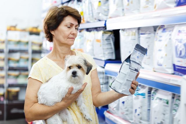 Woman and dog shopping for pet food