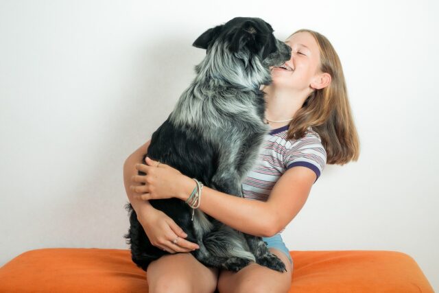 Girl smiling and hugging dog