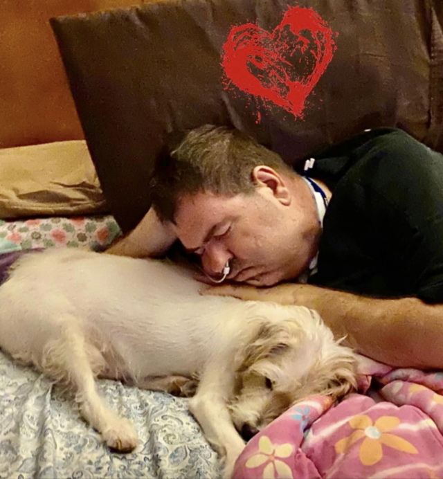 Dog comforting man with cancer