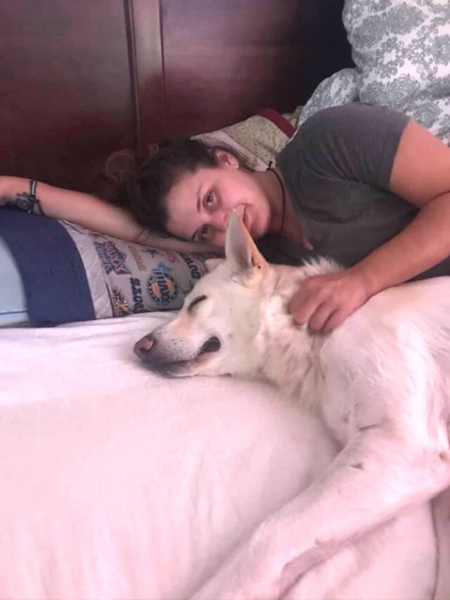 Woman cuddling dog