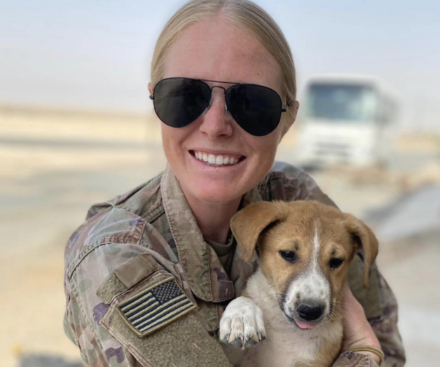 Military worker holding dog