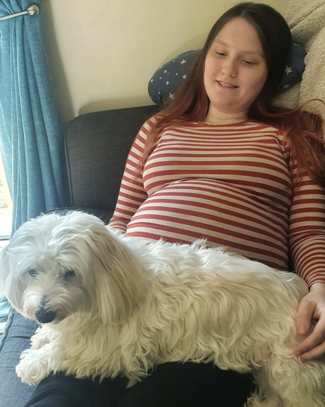 Pregnant woman cuddling dog