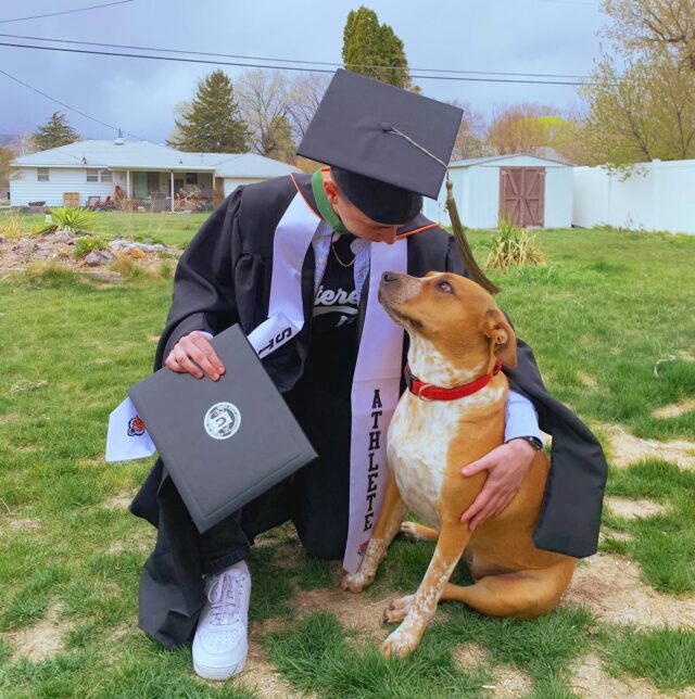 College graduate cuddling dog