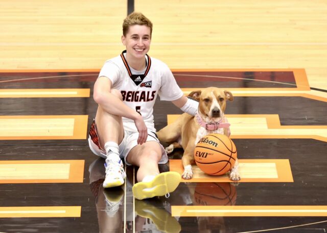 Student and dog on basketball court