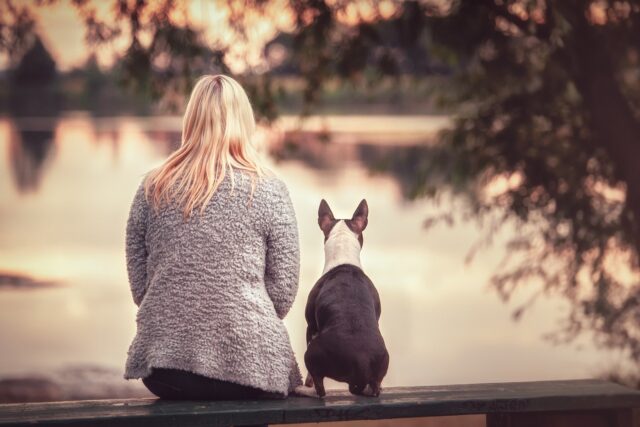 Woman with dog by water