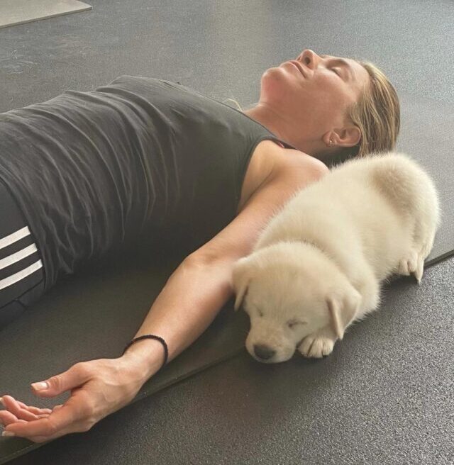 Jennifer Aniston laying with puppy