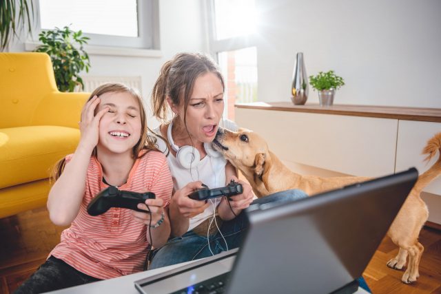 Mom, daughter, and dog play video games