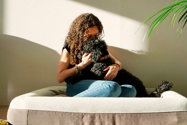 Woman and dog on dog bed