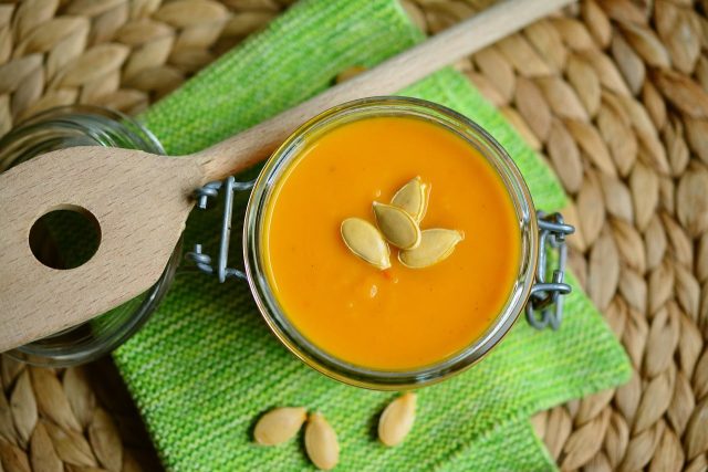 pureed pumpkin in a jar sitting on a green cloth