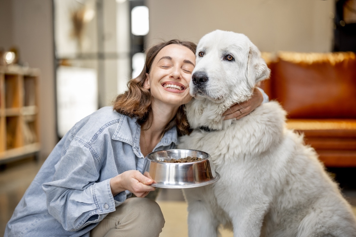 Happy dog with woman getting ready to eat.