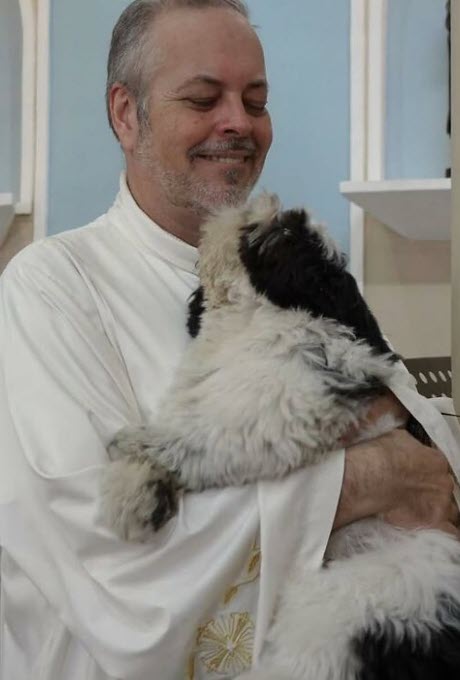 Dog hugs priest after adoption