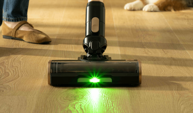 Close-up of the Levoit VortexIQ Pro floor head with the NeoSight green LED beam lighting pale hardwood